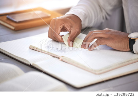 Hands, closeup and sticky note with book on desk for reading, studying and knowledge with planning for analysis. Person, reminder and notebook on table for schedule, project management and process 139299722