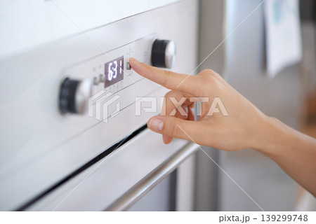 Closeup, hand and button on oven for cooking in kitchen for heating, preparation and appliance. Person, press and switch for electronic, equipment or technology with number display in home for timer Closeup, hand and button on oven for cooking in kitchen for heating, preparation and appliance. Person, press and switch for electronic, equipment or technology with number display in home for timer 139299748
