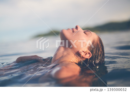 Ocean, swimming and woman with holiday, sea and relax with getaway trip, freedom and outdoor for fun. Person, traveller and girl with vacation, water and summer with weekend break, carefree or travel 139300032