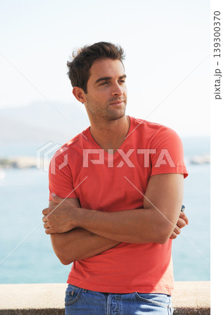 Confident, fashion and man by ocean in city for summer holiday, vacation and weekend outdoors. Sunglasses, travel and person in crossed arms by sea in trendy clothes, style and casual outfit to relax 139300370