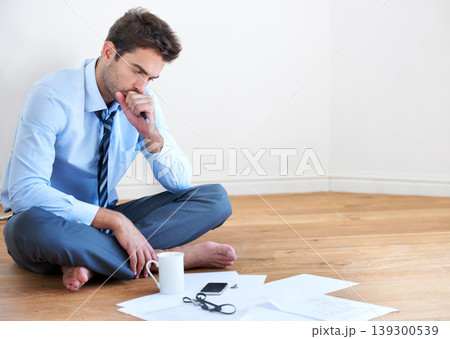 Stress, documents and finance with a business man reading tax paper or a budget on the floor of his apartment. Accounting, compliance and anxiety with a young employee looking worried about debt Stress, documents and finance with a business man reading tax paper or a budget on the floor of his apartment. Accounting, compliance and anxiety with a young employee looking worried about debt 139300539