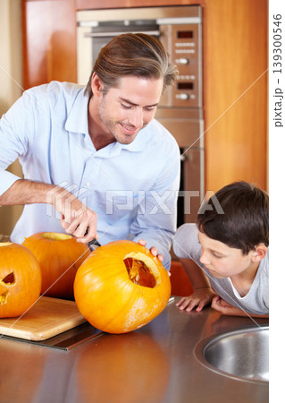 Halloween, pumpkin and father with kid in a kitchen for carving, learning or festival preparation at home. Family, love and parent with fruit, knife and creative lesson while. bonding with boy child 139300546