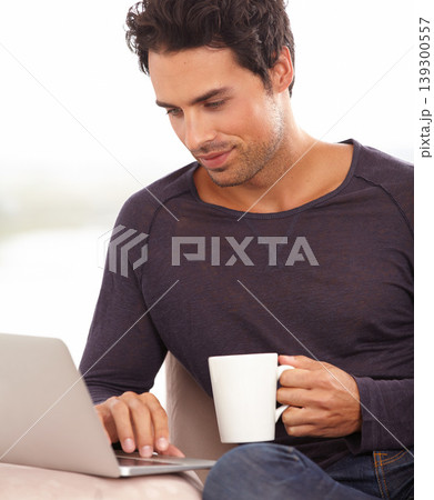 Coffee, laptop and online with man on sofa for social media, networking and connection. Website, streaming and digital with person in living room at home for remote work, research and technology Coffee, laptop and online with man on sofa for social media, networking and connection. Website, streaming and digital with person in living room at home for remote work, research and technology 139300557