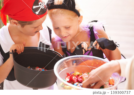 Siblings, trick o treat and halloween costume outdoor, sweets and happiness in community. Boy, girl or smile face for holiday with candy bucket, collect chocolates and fairy or pirate by neighbours Siblings, trick o treat and halloween costume outdoor, sweets and happiness in community. Boy, girl or smile face for holiday with candy bucket, collect chocolates and fairy or pirate by neighbours 139300737