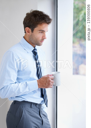 Businessman, drinking coffee and exhausted at work, window and burnout at office, depressed and stress. Male person, reflection and thinking on career, tired and overworked or mental health issues 139300806