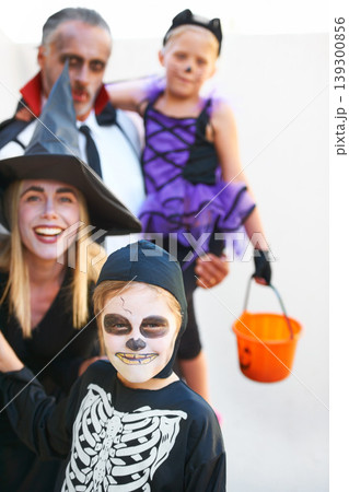 Portrait, halloween and a family in costume for the tradition of trick or treat or holiday celebration. Mother, father and kids at a door in fantasy clothes for dress up on allhallows eve together 139300856