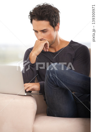 Man, work from home and thinking on laptop for stock market investment, reading information or website on sofa. Freelancer or trader on his computer with trading software, choice or online decision 139300971