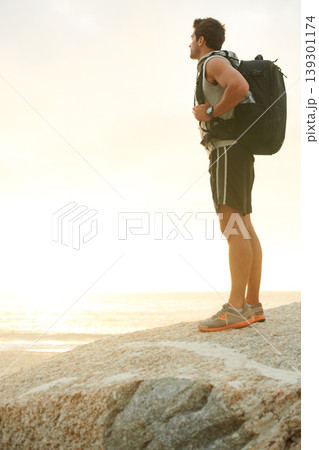 Man, backpack or rock and cliff in nature for travel, adventure or scenery with sunshine, thinking or view. Person, mountain or sky for holiday, vacation or experience outdoor and freedom or trekking 139301174