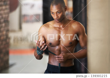 Fighting, gym and black man wrapping hands with fitness, power and training challenge. Strong body, muscle workout and boxer in gym, athlete with confidence and getting ready for boxing competition. Fighting, gym and black man wrapping hands with fitness, power and training challenge. Strong body, muscle workout and boxer in gym, athlete with confidence and getting ready for boxing competition. 139301215