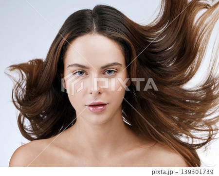 Hair care, woman or portrait and beauty in studio with wind, collagen treatment or brazilian for shine. Person, face and cosmetics with dermatology, keratin or glow with white background for wellness Hair care, woman or portrait and beauty in studio with wind, collagen treatment or brazilian for shine. Person, face and cosmetics with dermatology, keratin or glow with white background for wellness 139301739