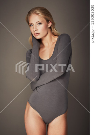 Portrait, bodysuit and fit woman with fashion on a grey studio background. Model, underwear and stylish female person with trendy clothing looking cool, serious and elegant in beautiful style Portrait, bodysuit and fit woman with fashion on a grey studio background. Model, underwear and stylish female person with trendy clothing looking cool, serious and elegant in beautiful style 139302039