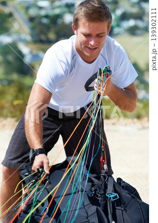 Man, safety harness or paragliding sport in launch in training, healthy adventure or extreme fitness. Person, preparation and fearless outdoor for flight with smile and parachute gear in countryside Man, safety harness or paragliding sport in launch in training, healthy adventure or extreme fitness. Person, preparation and fearless outdoor for flight with smile and parachute gear in countryside 139302111