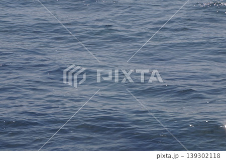太陽の光でキラキラと輝く海面と打ち寄せる波の泡 太陽の光でキラキラと輝く海面と打ち寄せる波の泡 139302118