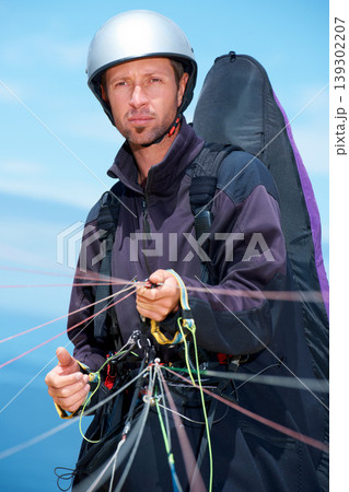 Paragliding, parachute and man with preparation in nature, strings and exercise for health support. Athlete, training or fitness for outdoor with safety harness, helmet or equipment in countryside 139302207
