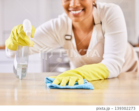 Happy woman, spray bottle and hands cleaning table in housekeeping, hygiene or disinfection in kitchen. Closeup of female person gloves wiping surface counter or furniture in bacteria or germ removal 139302273