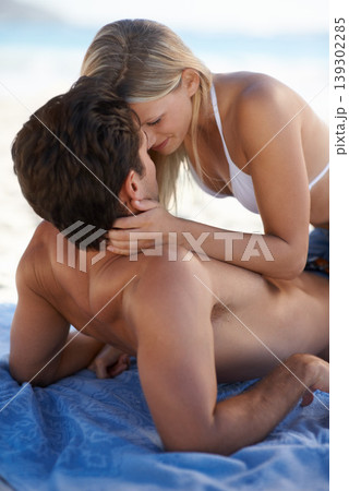 Beach, couple and embrace with love, support and care on holiday by the sea and ocean. Romance, bonding and kiss with young people together on vacation adventure on sand about to kiss on a date 139302285