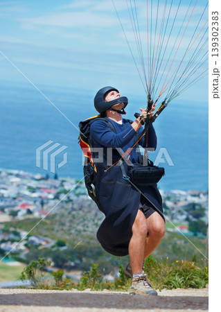 Man, parachute and paragliding launch in air in nature, healthy adventure and fun in extreme sport. Athlete, take off or fearless for outdoor fitness for wellness, helmet or safety gear by blue sky 139302383