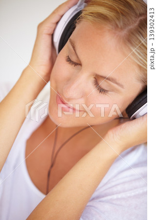 Woman, eyes closed and smile with headphones in closeup for music, podcast or radio. Person, calm or peaceful expression on face for listening, audio or song in home streaming service on internet Woman, eyes closed and smile with headphones in closeup for music, podcast or radio. Person, calm or peaceful expression on face for listening, audio or song in home streaming service on internet 139302413