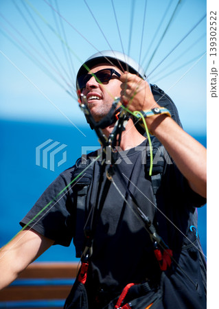 Man, parachute and paragliding launch in air in nature, exercise and healthy adventure fof extreme sport. Person, glide or fearless in outdoor fitness for wellness, helmet or safety gear by blue sky Man, parachute and paragliding launch in air in nature, exercise and healthy adventure fof extreme sport. Person, glide or fearless in outdoor fitness for wellness, helmet or safety gear by blue sky 139302522