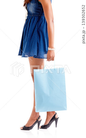 Woman, hand and legs with shopping bag in fashion or dress isolated against a white studio background. Female person, shopper or model walking with gift, present or sale discount on clothing purchase Woman, hand and legs with shopping bag in fashion or dress isolated against a white studio background. Female person, shopper or model walking with gift, present or sale discount on clothing purchase 139302652