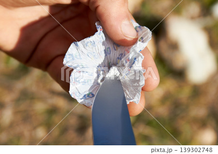 Person, hand and knife with cocaine, drugs or sample for recreation, addiction or habit outdoor. Man, product and packaging on grass in nature with weapon, illegal or unhealthy lifestyle or substance Person, hand and knife with cocaine, drugs or sample for recreation, addiction or habit outdoor. Man, product and packaging on grass in nature with weapon, illegal or unhealthy lifestyle or substance 139302748