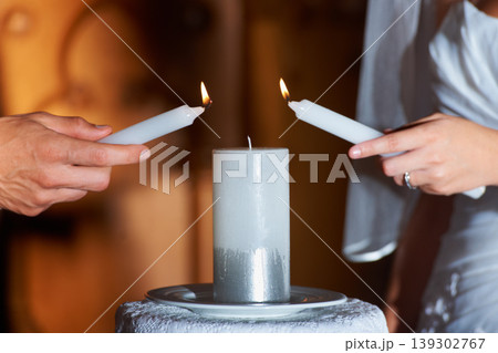 Couple, hands and candle at wedding for love, unity and commitment at church or ceremony with closeup. Marriage, man and woman with light for trust, relationship and compromise with bride and groom Couple, hands and candle at wedding for love, unity and commitment at church or ceremony with closeup. Marriage, man and woman with light for trust, relationship and compromise with bride and groom 139302767