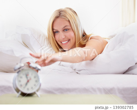 Happy woman, stop and alarm clock for time in bedroom with noise, sound or alert for waking up. Person, smile and excited expression on face for early morning by pressing, button and switch in home Happy woman, stop and alarm clock for time in bedroom with noise, sound or alert for waking up. Person, smile and excited expression on face for early morning by pressing, button and switch in home 139302785