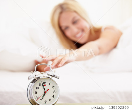 Woman, stop and alarm clock for time in bedroom with noise, sound or alert for waking up. Happy person, smile and excited expression on face to press, switch and off for early morning, start and day 139302899