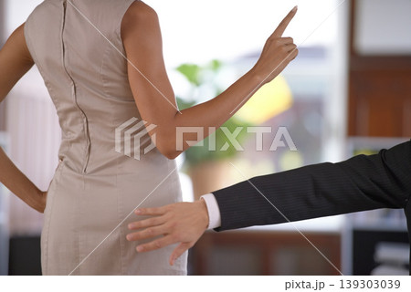 Hand, butt and sexual harassment with a business person slapping the behind of a woman coworker in the office. Ethics, behaviour or no with an employee reaching to smack the bottom of a colleague Hand, butt and sexual harassment with a business person slapping the behind of a woman coworker in the office. Ethics, behaviour or no with an employee reaching to smack the bottom of a colleague 139303039