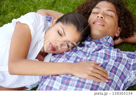 Grass, happy and couple relax in garden outdoors for bonding, loving relationship and date. Dating, nature and man and woman with eyes closed together in field for romantic picnic, holiday or weekend 139303134
