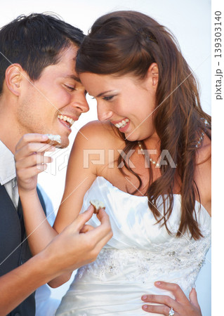 Happy, wedding and couple eating cake together for celebration of love together at party. Smile, cute and young bride feed husband sweet dessert at romantic marriage ceremony or event with commitment Happy, wedding and couple eating cake together for celebration of love together at party. Smile, cute and young bride feed husband sweet dessert at romantic marriage ceremony or event with commitment 139303140