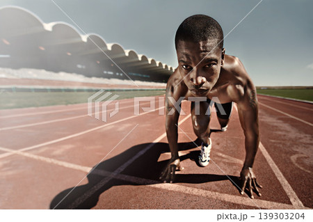 Man, runner and starting line for race, face and ready for marathon, sports and sprint or competition. Black male person, training and exercising or active, practice and outdoors for fitness on track Man, runner and starting line for race, face and ready for marathon, sports and sprint or competition. Black male person, training and exercising or active, practice and outdoors for fitness on track 139303204