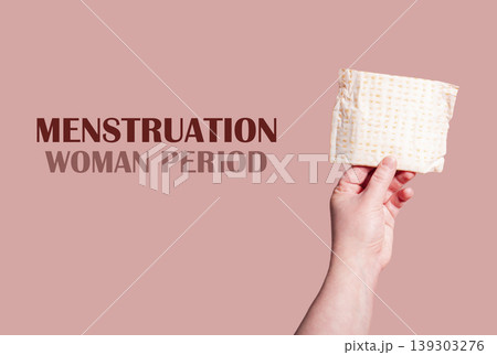 Classic menstrual pads in woman hand. Menstrual cycle and suffering from menstrual pain. Female period and intimate hygiene Classic menstrual pads in woman hand. Menstrual cycle and suffering from menstrual pain. Female period and intimate hygiene 139303276