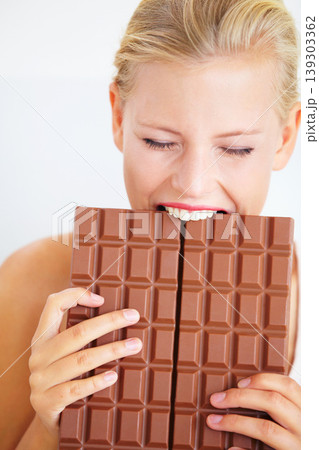 Eating woman, hungry and bite chocolate bar, delicious snack or candy for studio food, dessert or sugar craving. Diet cheat meal calories, diabetes or girl hunger for cacao sweets on white background Eating woman, hungry and bite chocolate bar, delicious snack or candy for studio food, dessert or sugar craving. Diet cheat meal calories, diabetes or girl hunger for cacao sweets on white background 139303362