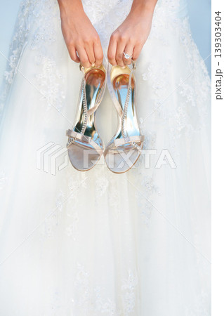 Hands, wedding and closeup of a bride with shoes and dress for luxury, elegant and romantic event. Zoom of woman with silver, fashion and bridal heels and garments marriage ceremony or celebration. Hands, wedding and closeup of a bride with shoes and dress for luxury, elegant and romantic event. Zoom of woman with silver, fashion and bridal heels and garments marriage ceremony or celebration. 139303404