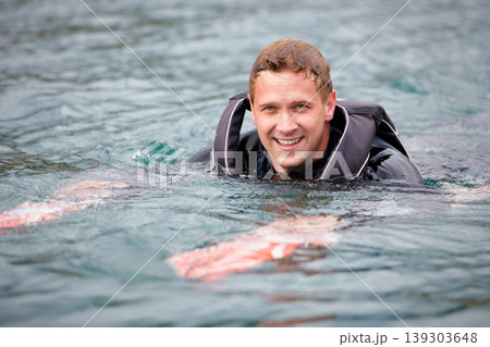Man, water ski and portrait in lake, happy and waiting for tow with fitness, extreme sports or exercise. Person, smile and outdoor in river, nature and float with swimming, health and summer training Man, water ski and portrait in lake, happy and waiting for tow with fitness, extreme sports or exercise. Person, smile and outdoor in river, nature and float with swimming, health and summer training 139303648