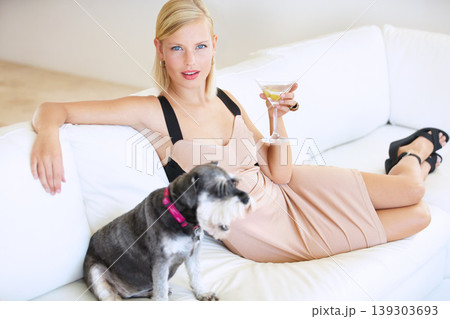 Woman, drinking alcohol and relaxing on couch, dog and portrait or companionship, pet and vacation. Female person, martini and face for fun, confident and elegant fashion at home, freedom and love Woman, drinking alcohol and relaxing on couch, dog and portrait or companionship, pet and vacation. Female person, martini and face for fun, confident and elegant fashion at home, freedom and love 139303693