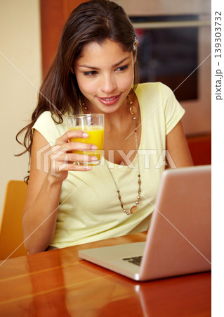 Morning, laptop and woman doing remote work with juice for breakfast in a home. Table, online and working freelancer with social media scroll and computer with a smile from technology in a house Morning, laptop and woman doing remote work with juice for breakfast in a home. Table, online and working freelancer with social media scroll and computer with a smile from technology in a house 139303732