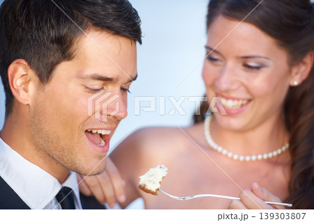 Happy, wedding and couple eating cake together for celebration of love together at party. Smile, cute and young bride feed husband sweet dessert at romantic marriage ceremony or event with commitment Happy, wedding and couple eating cake together for celebration of love together at party. Smile, cute and young bride feed husband sweet dessert at romantic marriage ceremony or event with commitment 139303807
