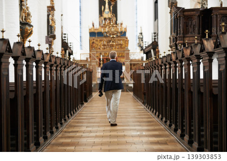 Walking, aisle and senior man in a church for sightseeing on a weekend trip, vacation or holiday. Faith, religion and back of holy elderly male person in retirement in worship cathedral in the city. 139303853