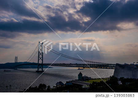 【夕景パノラマ】雲の隙間から差し込む光芒と明石海峡大橋のスケール感あふれる絶景 139303863