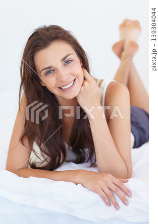 Smile, bed and portrait of woman in morning, relax and natural wellness in home on summer weekend. Wake up, healthy rest and peace, happy face of girl in bedroom of apartment, hotel room or house. 139304044