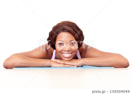 Black woman, portrait and smile on yoga mat with fitness, exercise and workout in studio. White background, calm and break with a happy African female person with health and wellness rest on ground Black woman, portrait and smile on yoga mat with fitness, exercise and workout in studio. White background, calm and break with a happy African female person with health and wellness rest on ground 139304049