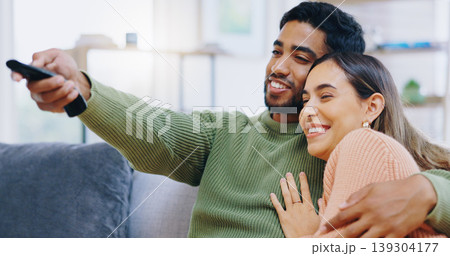 Couple, watching tv and remote on living room sofa with smile, hug or relax with click for choice, show or film. Man, woman and happy together for embrace, movie or streaming on lounge couch in home Couple, watching tv and remote on living room sofa with smile, hug or relax with click for choice, show or film. Man, woman and happy together for embrace, movie or streaming on lounge couch in home 139304177