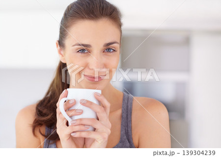 Woman, portrait and smile in kitchen with coffee, espresso or cappuccino for morning break or peace. Person, face and happy with beverage or herbal tea for relax, positivity or motivation in home 139304239