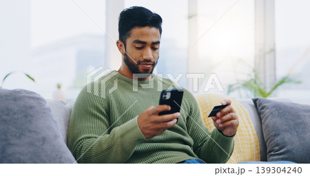 Man, credit card and phone on living room sofa with online shopping, ecommerce and decision with sale. Person, smartphone and easy payment with click, banking and fintech on lounge couch in home 139304240