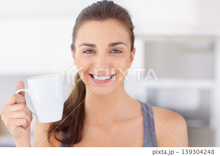 Portrait, smile and young woman drinking coffee in the kitchen of her home to wake up in the morning. Face, wellness and time off with a happy person in an apartment to enjoy a warm caffeine beverage Portrait, smile and young woman drinking coffee in the kitchen of her home to wake up in the morning. Face, wellness and time off with a happy person in an apartment to enjoy a warm caffeine beverage 139304248