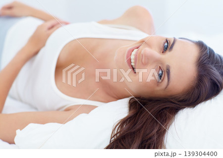 Smile, bed and wake up, portrait of woman in morning and natural wellness in home on summer weekend. Relax, healthy rest and peace, happy face of girl in bedroom of apartment, hotel room or house 139304400