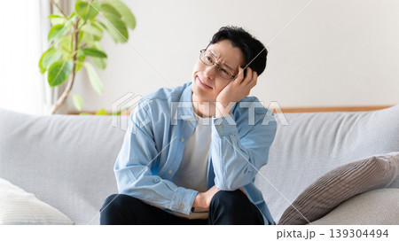 リビングのソファに座って考える男性 139304494