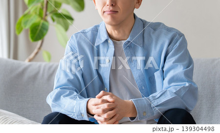 リビングのソファに座って考える男性 139304498